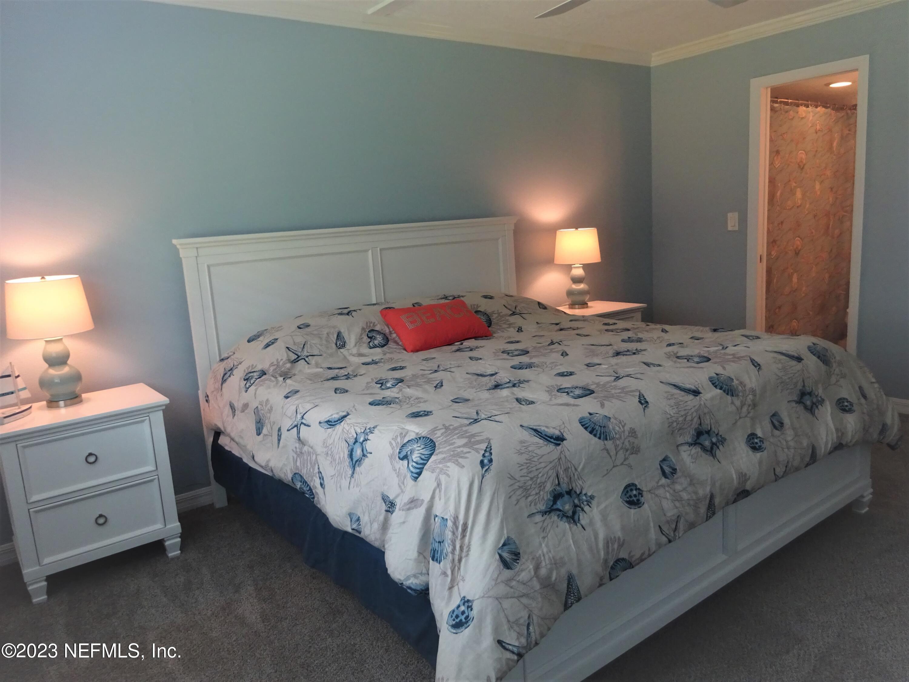 7175 A1A South, Unit F141 St. Augustine, FL 32080 - Photo 11 of 36 a bedroom with a bed and a lamp on dresser