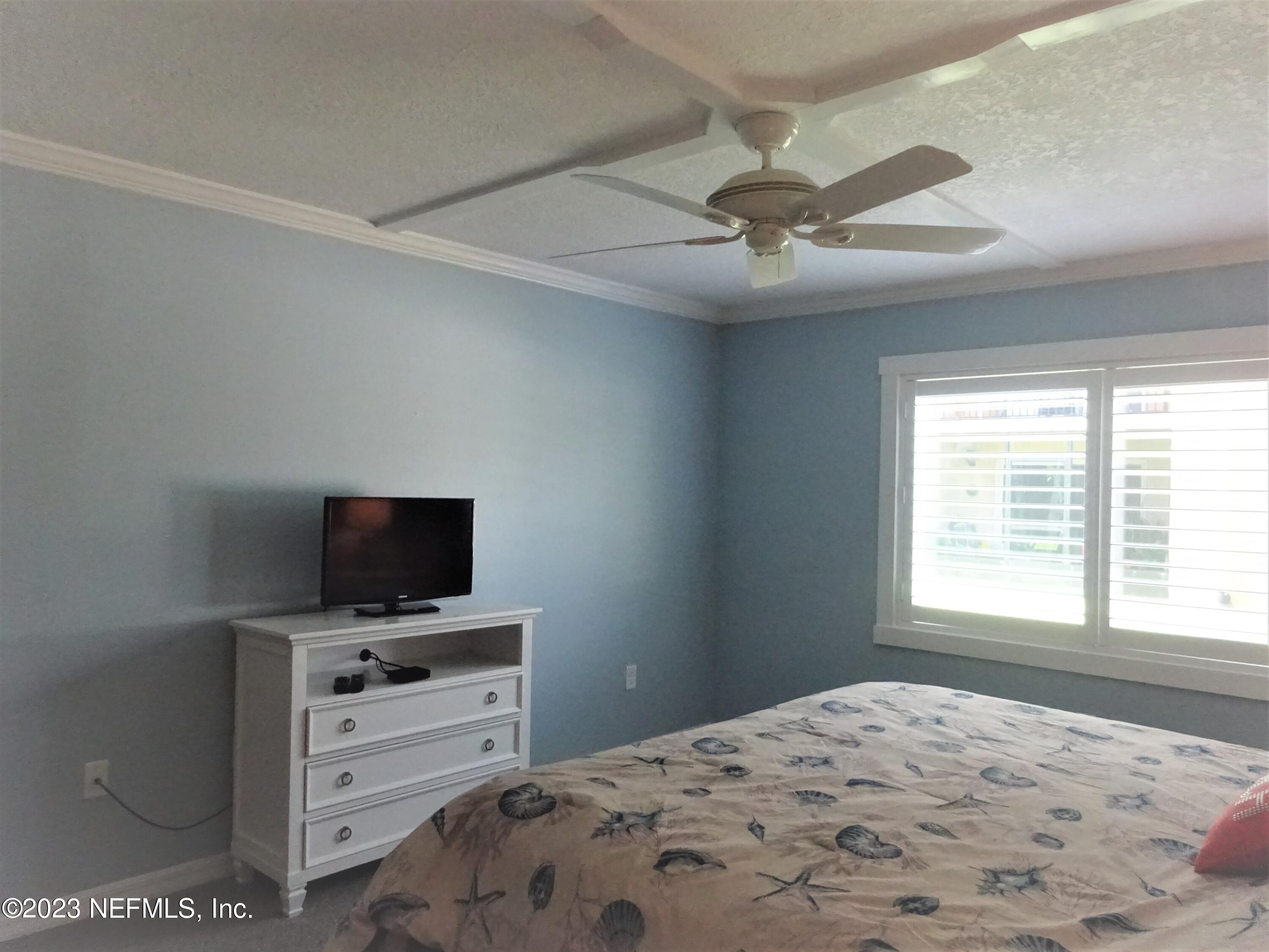 7175 A1A South, Unit F141 St. Augustine, FL 32080 - Photo 12 of 36 a bedroom with a bed and a flat screen tv