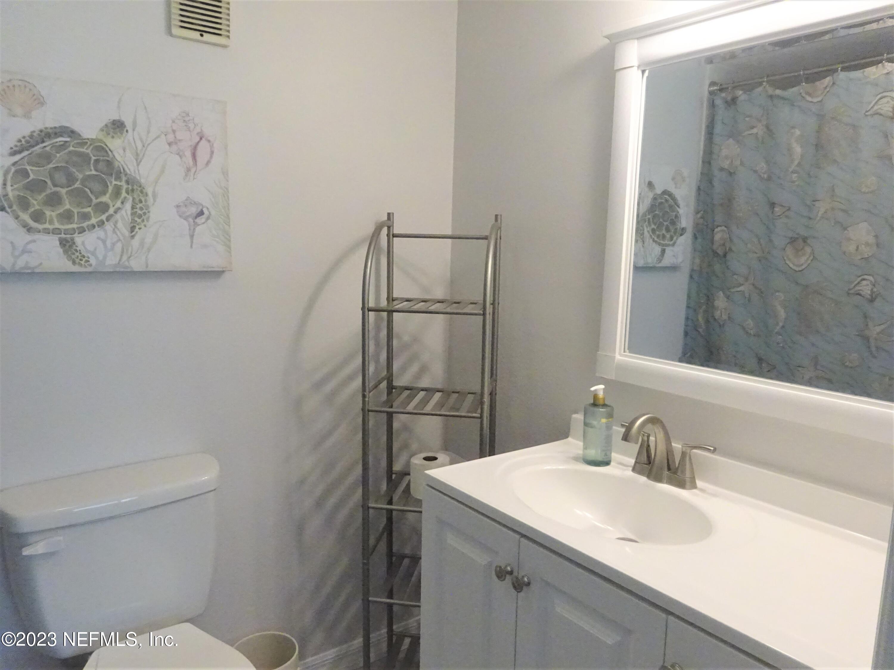 7175 A1A South, Unit F141 St. Augustine, FL 32080 - Photo 14 of 36 a bathroom with a sink toilet and vanity