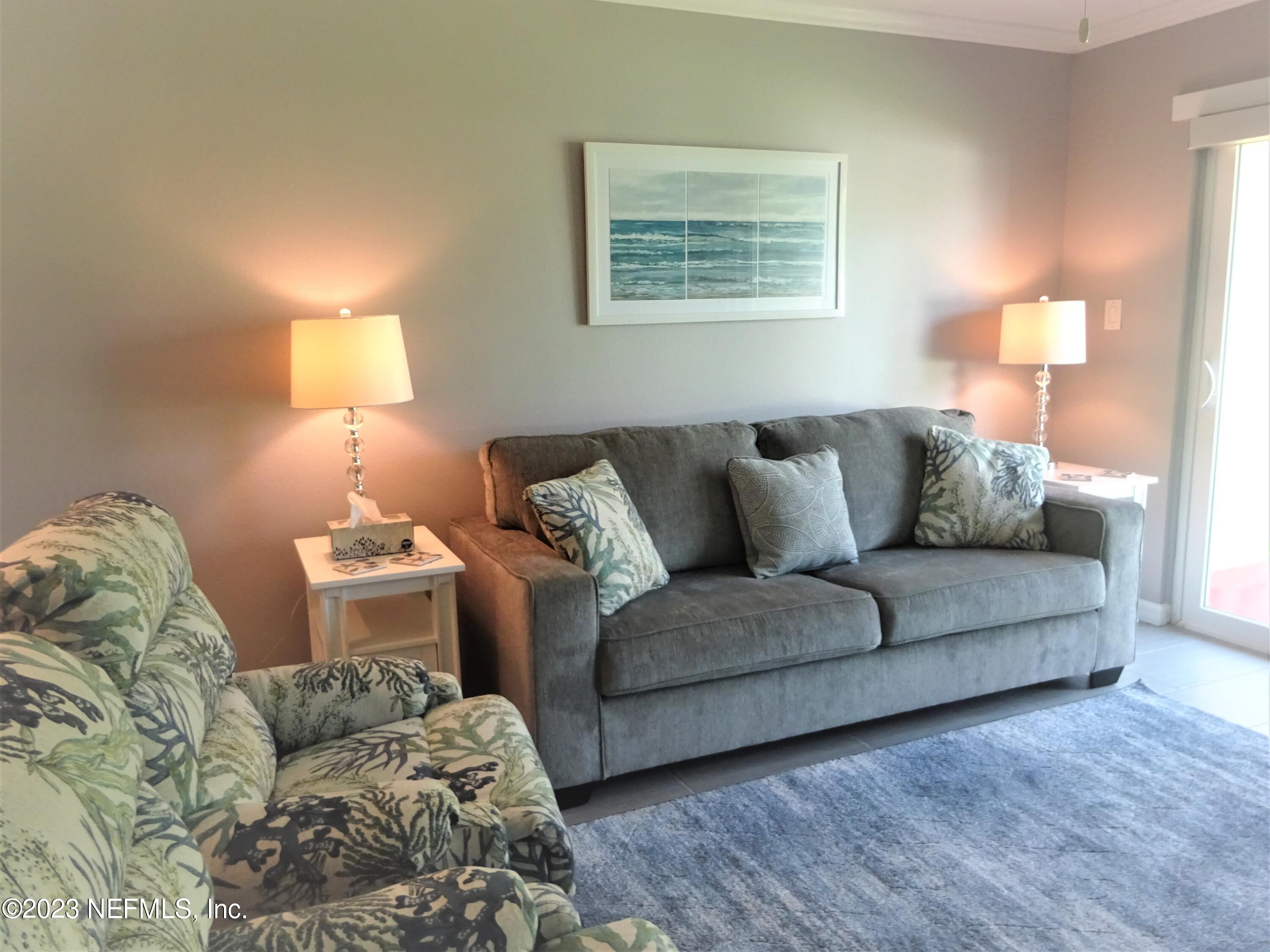 7175 A1A South, Unit F141 St. Augustine, FL 32080 - Photo 7 of 36 a living room with furniture and a lamp