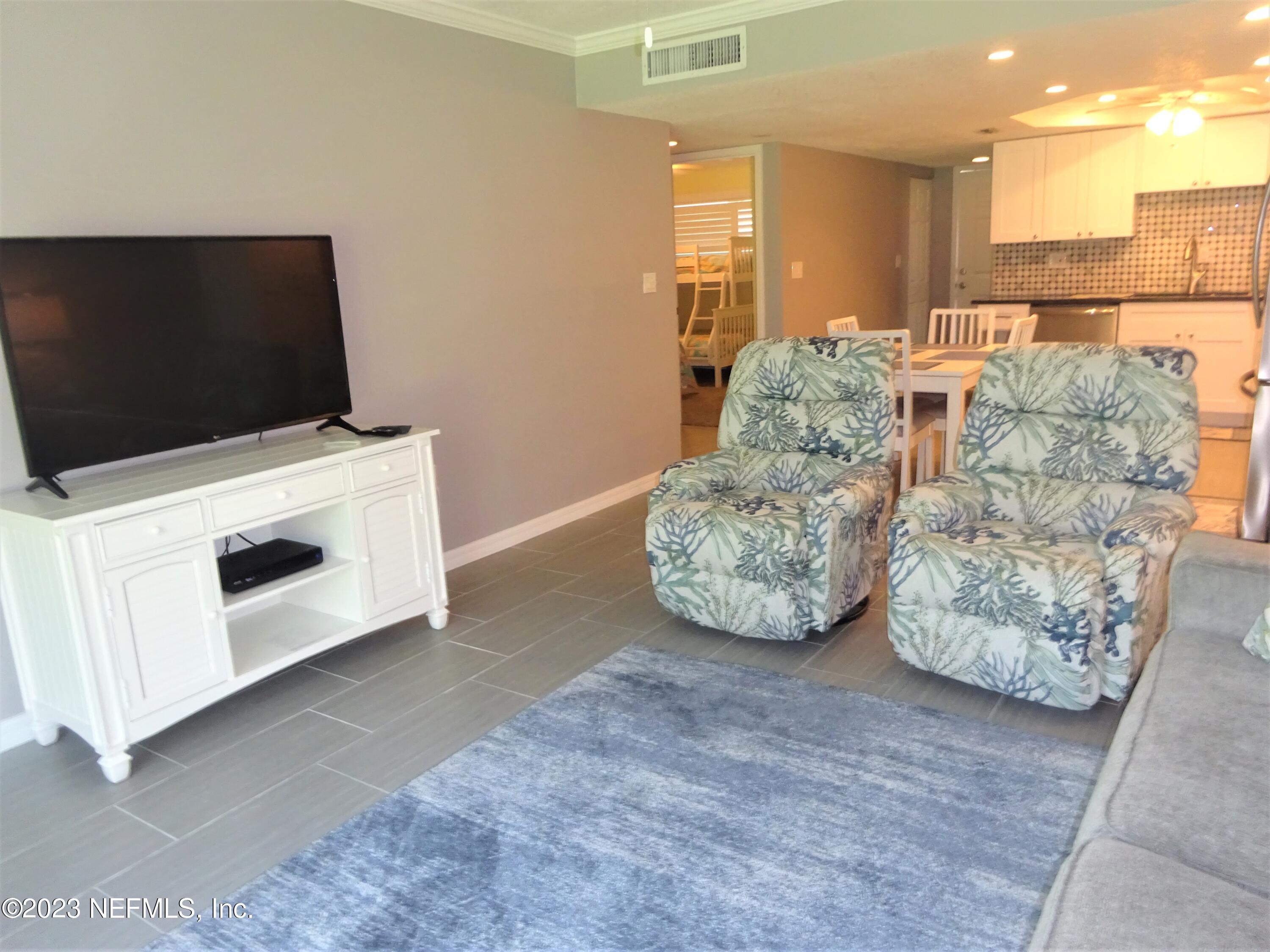 7175 A1A South, Unit F141 St. Augustine, FL 32080 - Photo 8 of 36 a living room with furniture and a flat screen tv