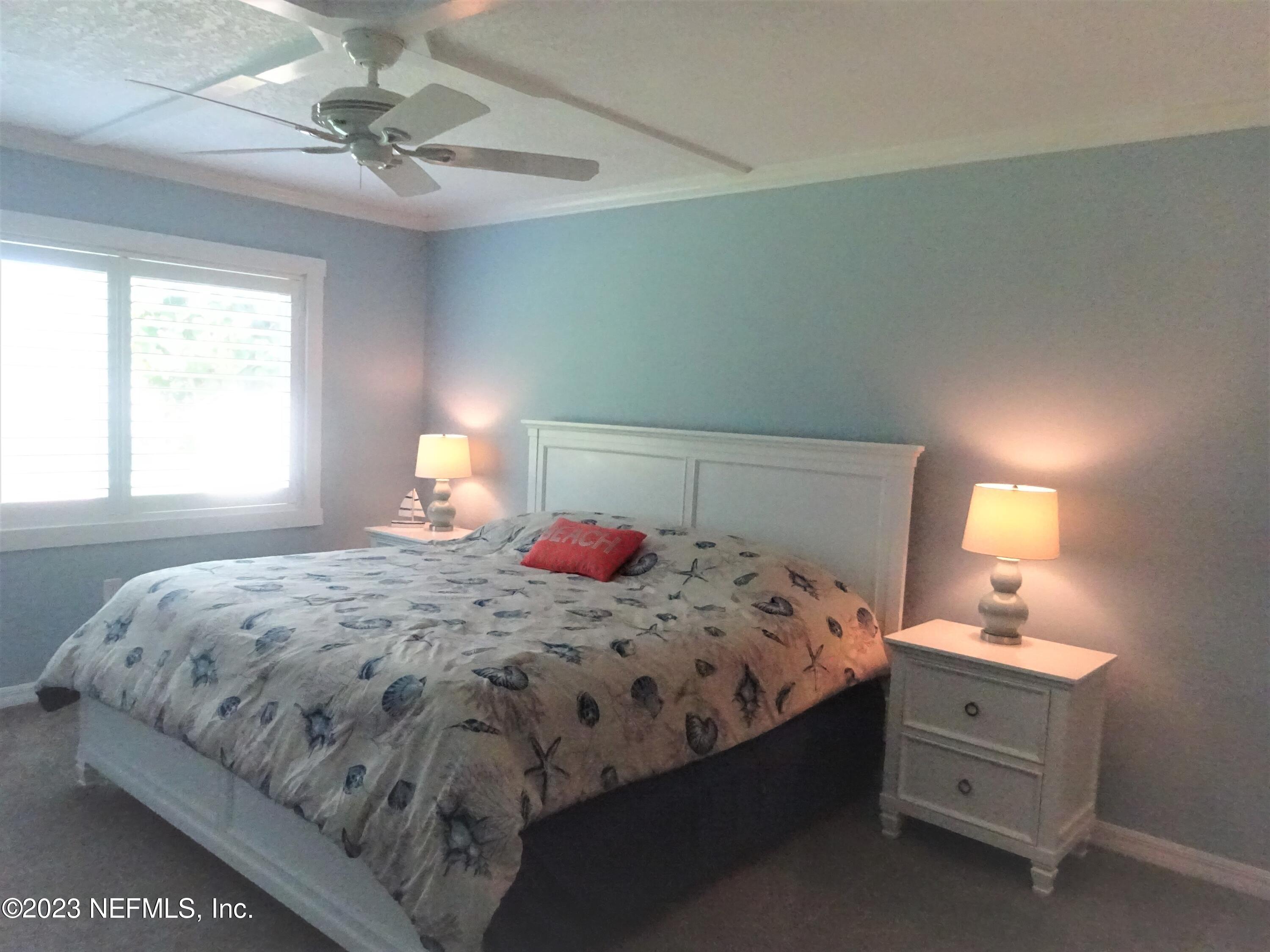 7175 A1A South, Unit F141 St. Augustine, FL 32080 - Photo 10 of 36 a bedroom with a bed and a lamp