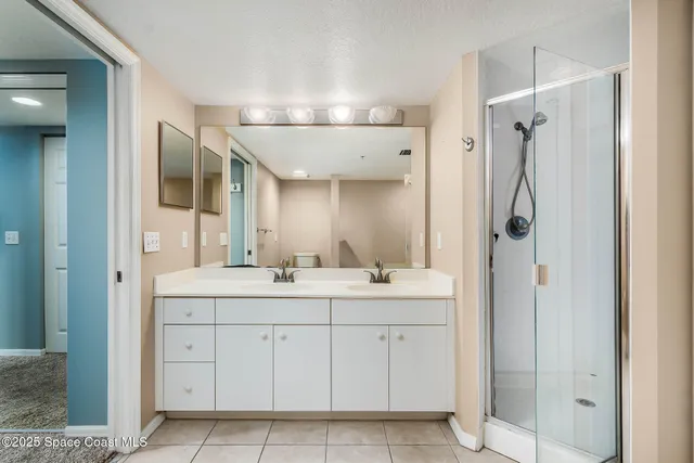 a spacious bathroom with a shower a sink and mirror
