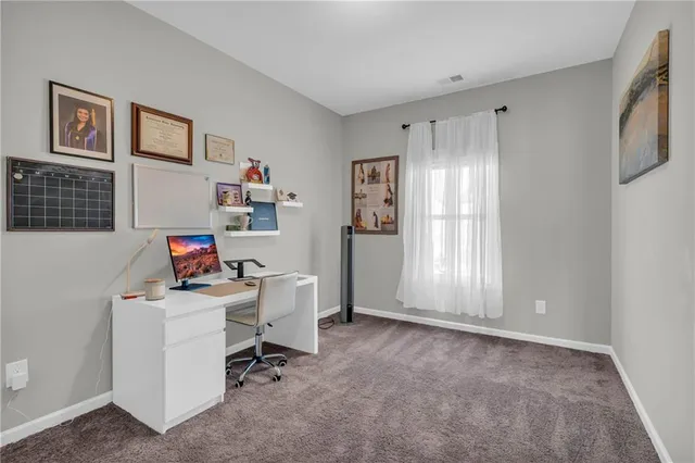 a view of a workspace with furniture and a window