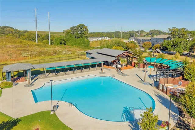 a view of a swimming pool with a lawn chairs under an umbrella