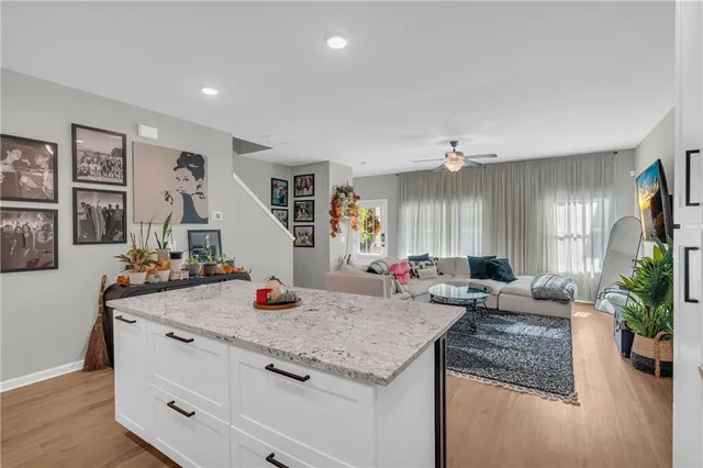 a kitchen view with living room couch and wooden floor