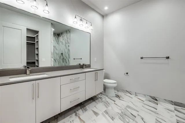 a bathroom with a granite countertop sink mirror and toilet