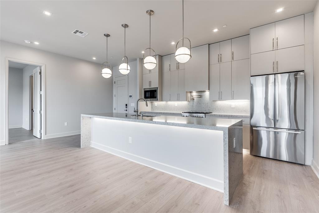 1900 South Ervay Street, Unit 512 Dallas, TX 75215 - Photo 7 of 22 a view of a kitchen with a refrigerator a stove and wooden floor
