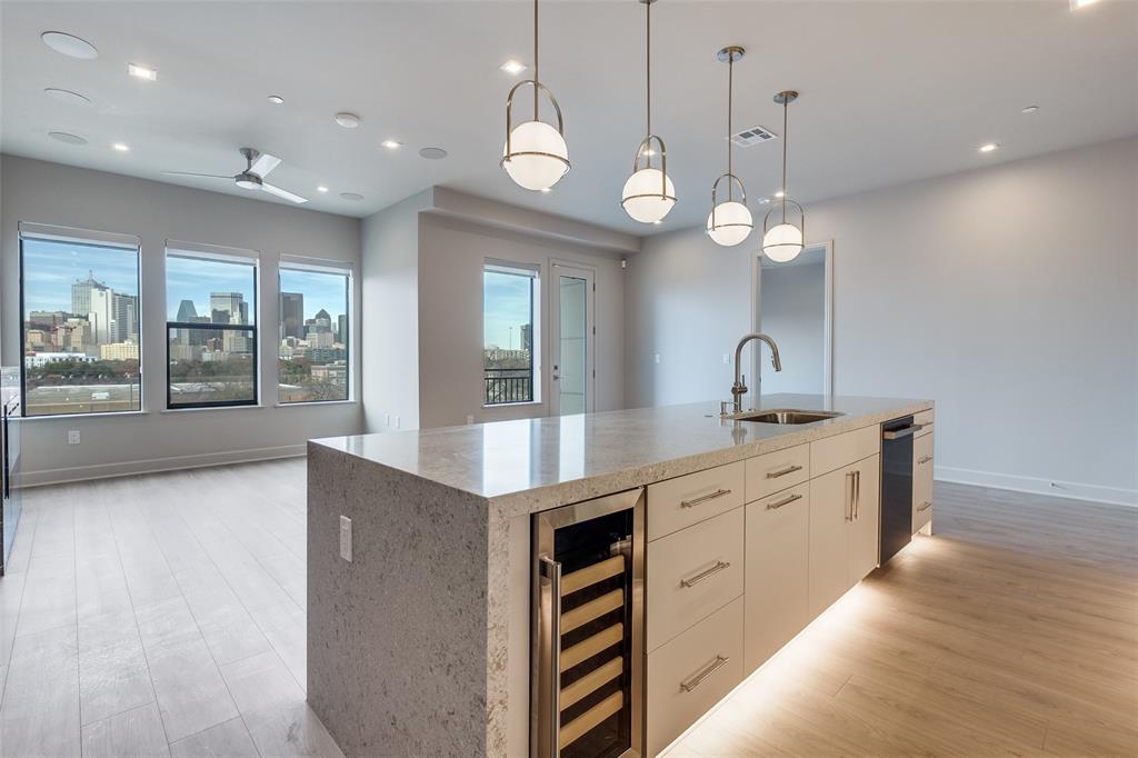 1900 South Ervay Street, Unit 512 Dallas, TX 75215 - Photo 8 of 22 a large kitchen with granite countertop a large kitchen island white cabinets and stainless steel appliances