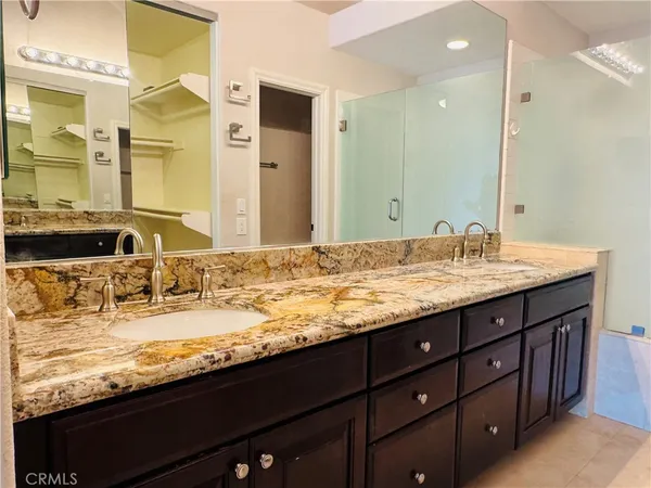 a bathroom with a granite countertop sink and a mirror