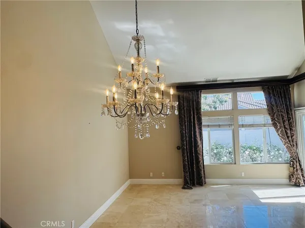 a view of a livingroom with a chandelier wooden floor and a chandelier