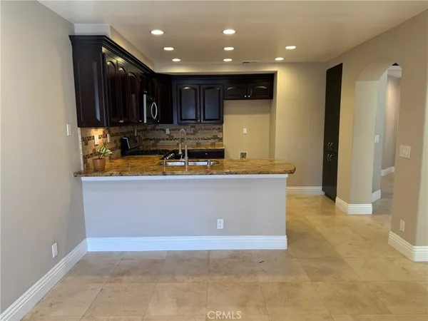 a view of kitchen with stainless steel appliances granite countertop refrigerator stove and oven