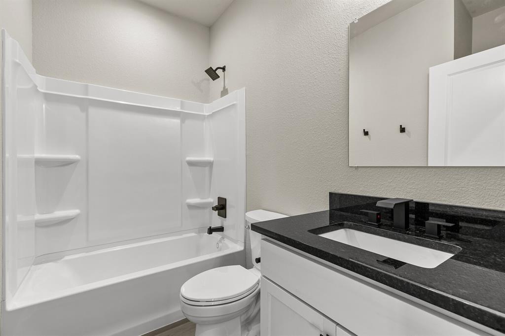 2913 Mildred Street Waco, TX 76706 - Photo 24 of 33 Full bath featuring a textured wall, vanity, and shower / washtub combination
