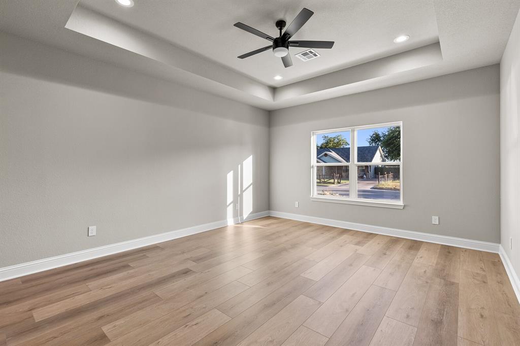 2913 Mildred Street Waco, TX 76706 - Photo 26 of 33 Spare room featuring a tray ceiling, recessed lighting, light wood-style flooring, and a ceiling fan