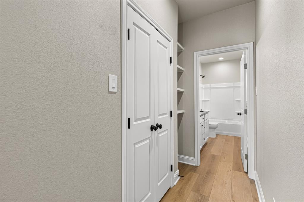 2913 Mildred Street Waco, TX 76706 - Photo 28 of 33 Hallway featuring light wood-style floors and a textured wall