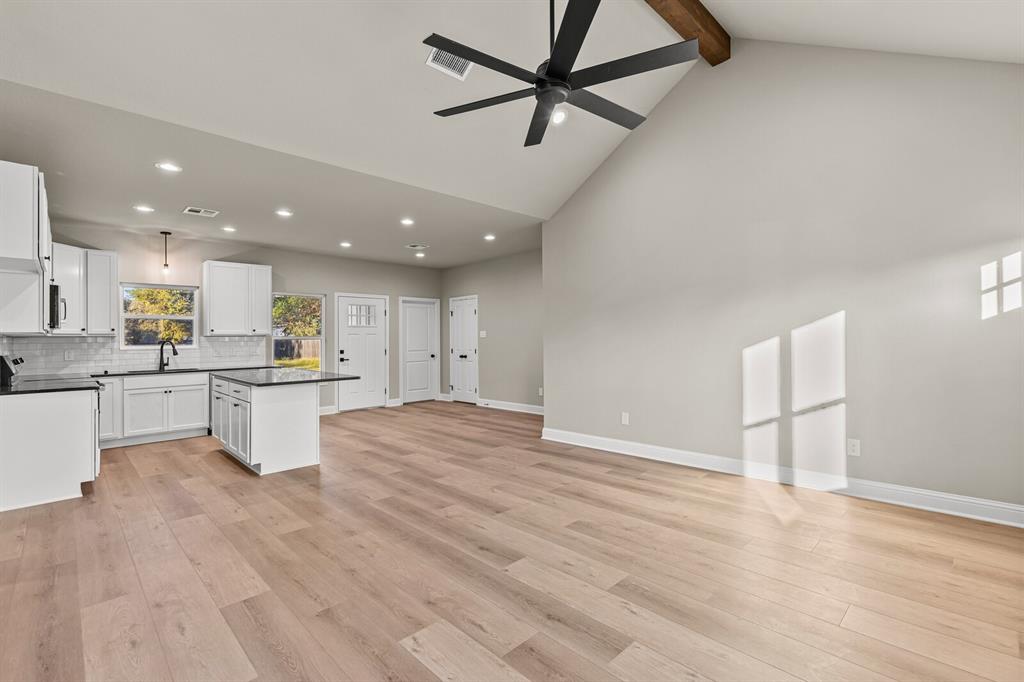 2913 Mildred Street Waco, TX 76706 - Photo 33 of 33 Kitchen featuring open floor plan, white cabinetry, a kitchen island, light wood finished floors, and beamed ceiling