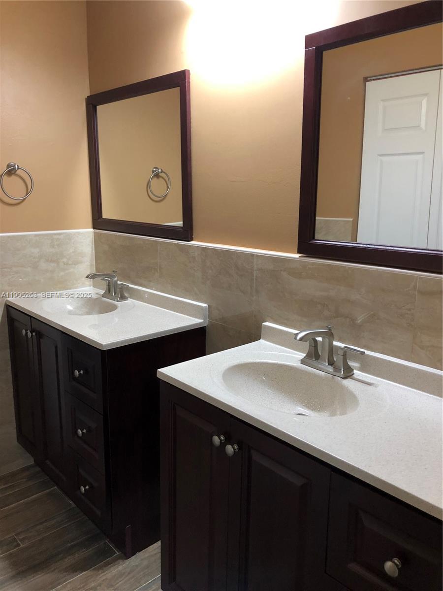 15065 Southwest 49th Lane, Unit E109 Miami, FL 33185 - Photo 16 of 21 a bathroom with a double vanity sink and a mirror