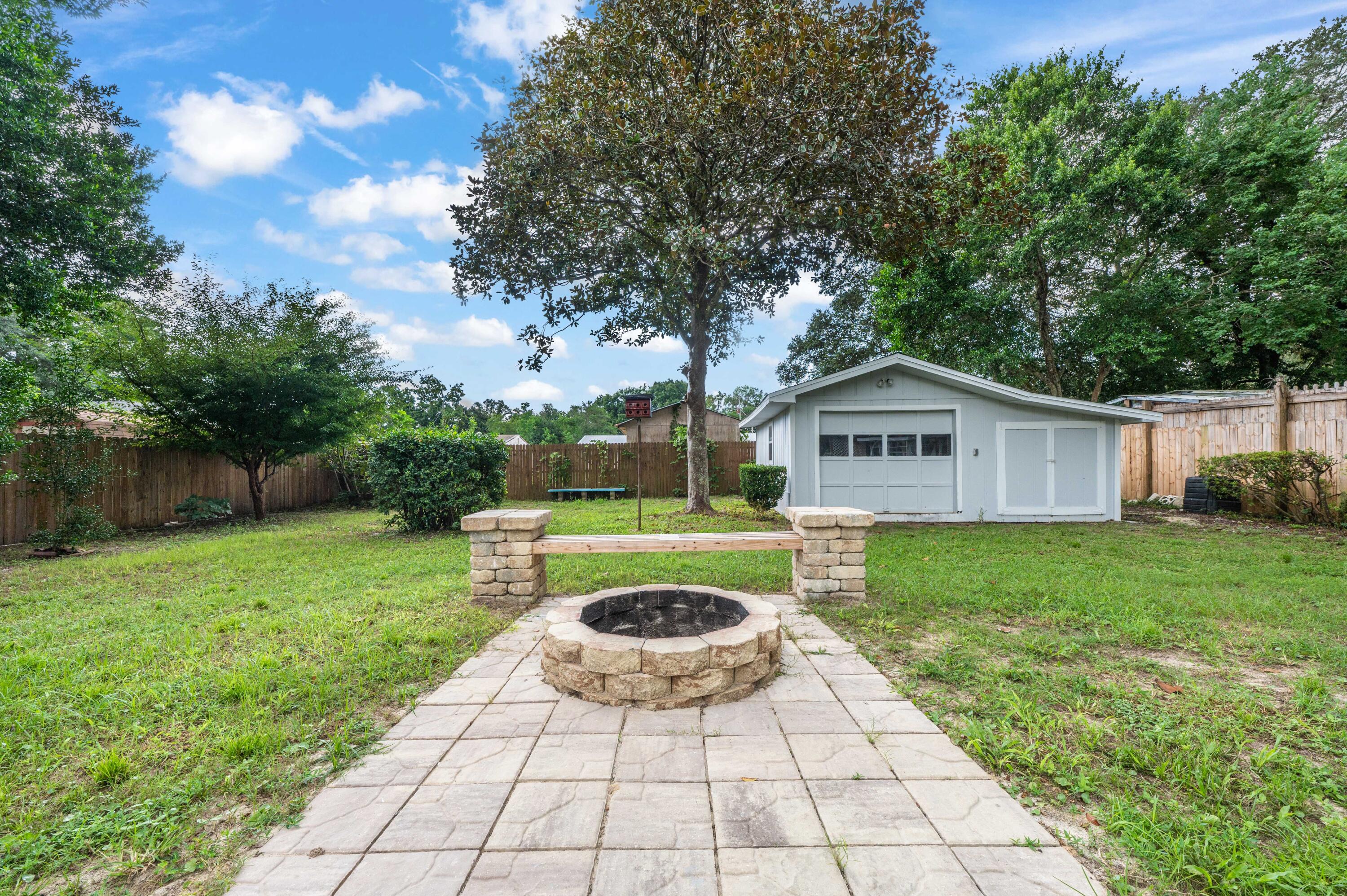 413 Gerold Street Fort Walton Beach, FL 32547 - Photo 73 of 91 a view of a backyard with table and chairs plants and large tree