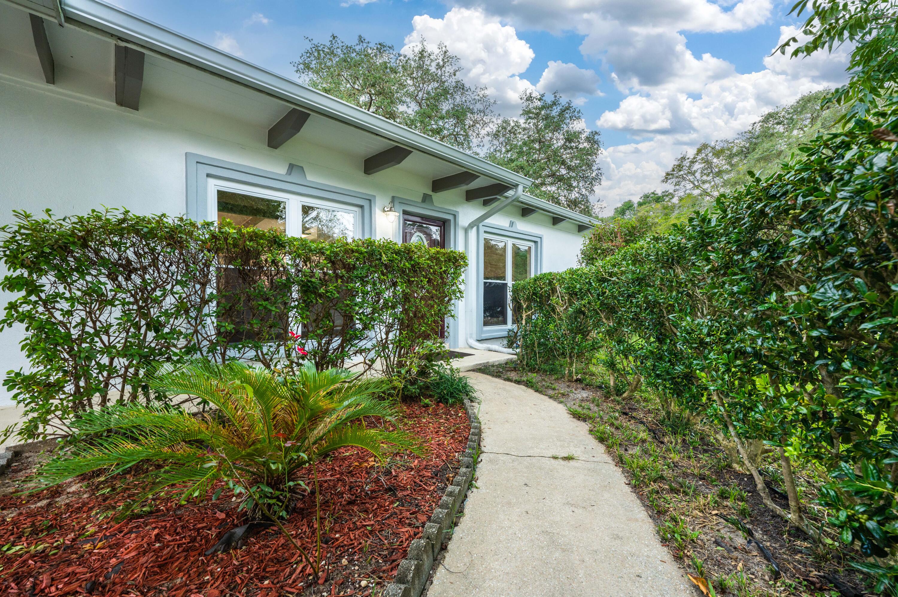 413 Gerold Street Fort Walton Beach, FL 32547 - Photo 9 of 91 a view of a house with a small yard plants and large tree