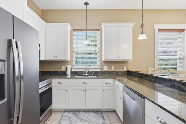a kitchen with granite countertop cabinets stainless steel appliances and a sink