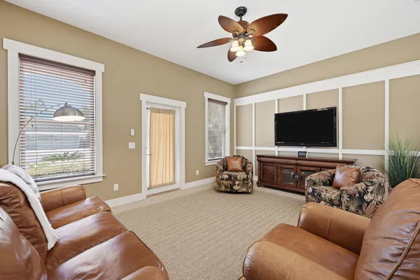 a living room with furniture kitchen view and a chandelier