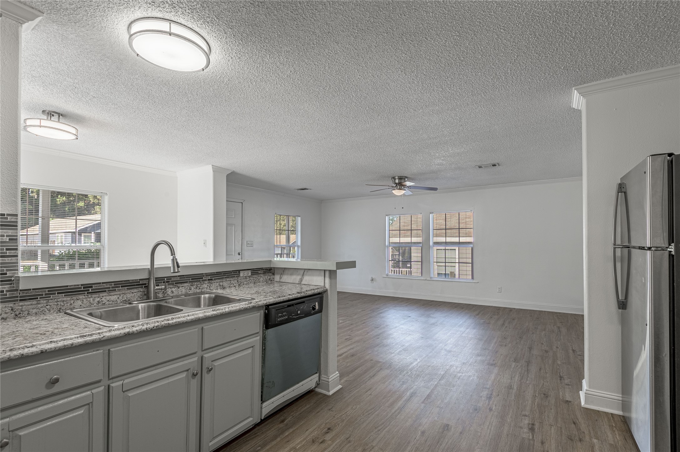 121 Varsity Circle Huntsville, TX 77340 - Photo 11 of 32 a kitchen with granite countertop a sink cabinets and wooden floor