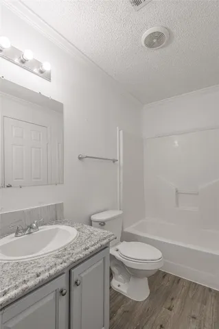 a bathroom with a granite countertop sink a toilet and shower