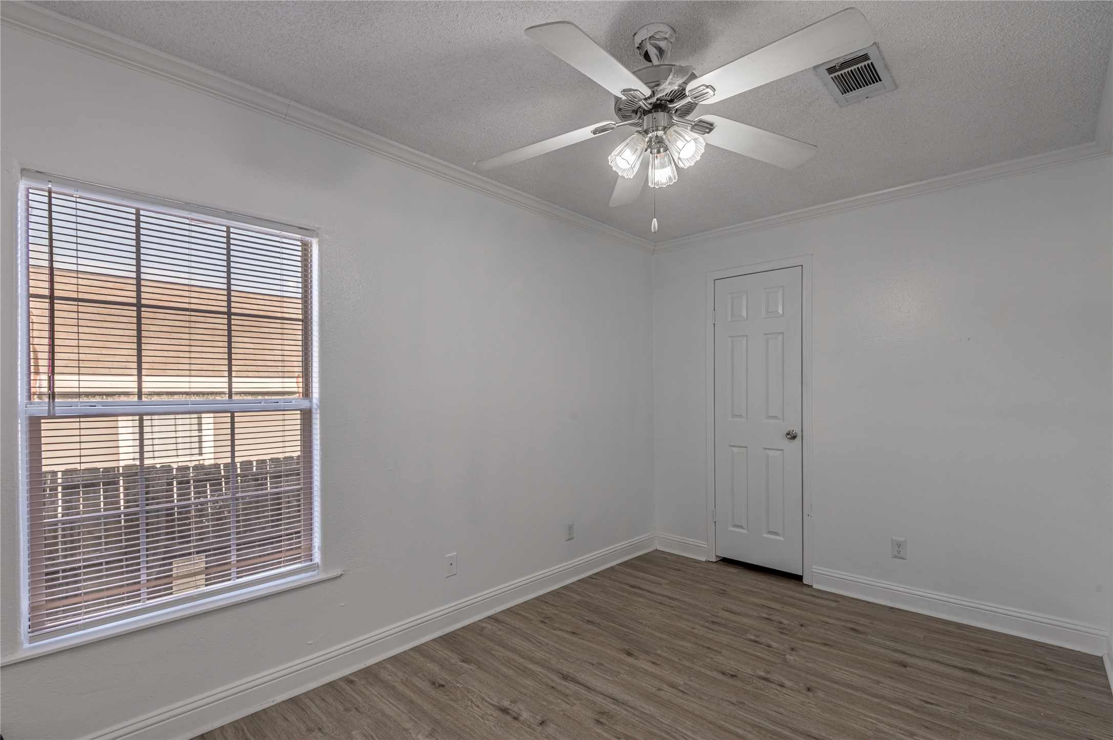 121 Varsity Circle Huntsville, TX 77340 - Photo 14 of 32 a view of an empty room with wooden floor and a window