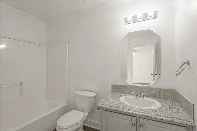 a bathroom with a granite countertop sink a toilet and a mirror