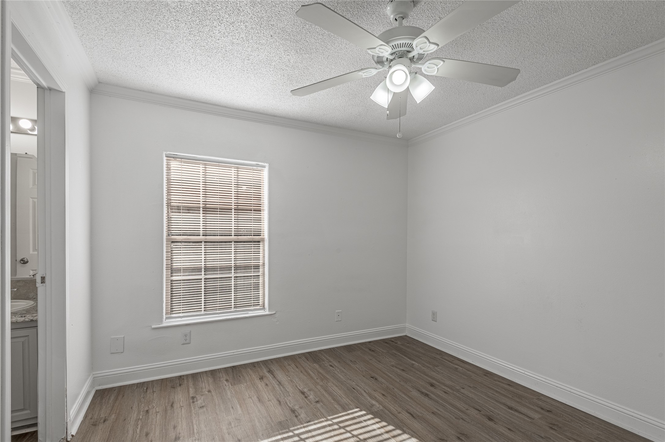 121 Varsity Circle Huntsville, TX 77340 - Photo 21 of 32 an empty room with wooden floor chandelier fan and windows