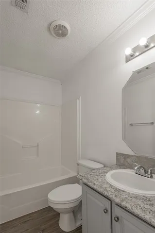 a bathroom with a granite countertop sink a toilet and a mirror