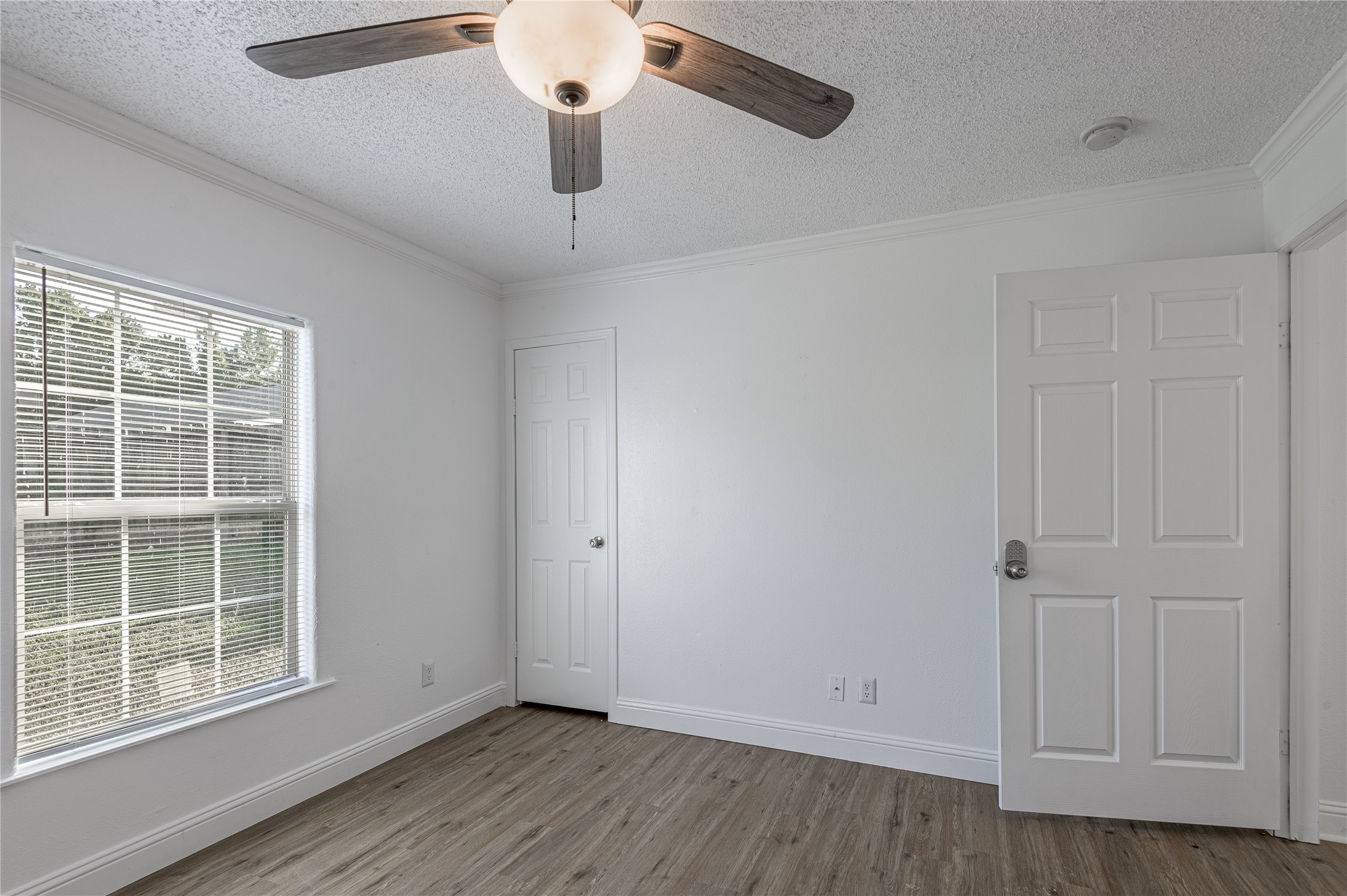 121 Varsity Circle Huntsville, TX 77340 - Photo 26 of 32 an empty room with wooden floor and windows