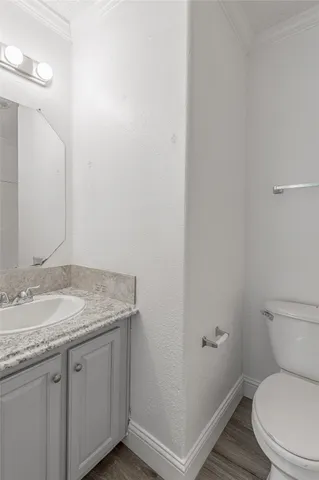 a bathroom with a granite countertop toilet and a sink