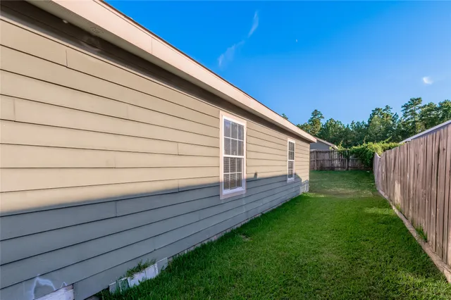 a view of a backyard with wooden fence