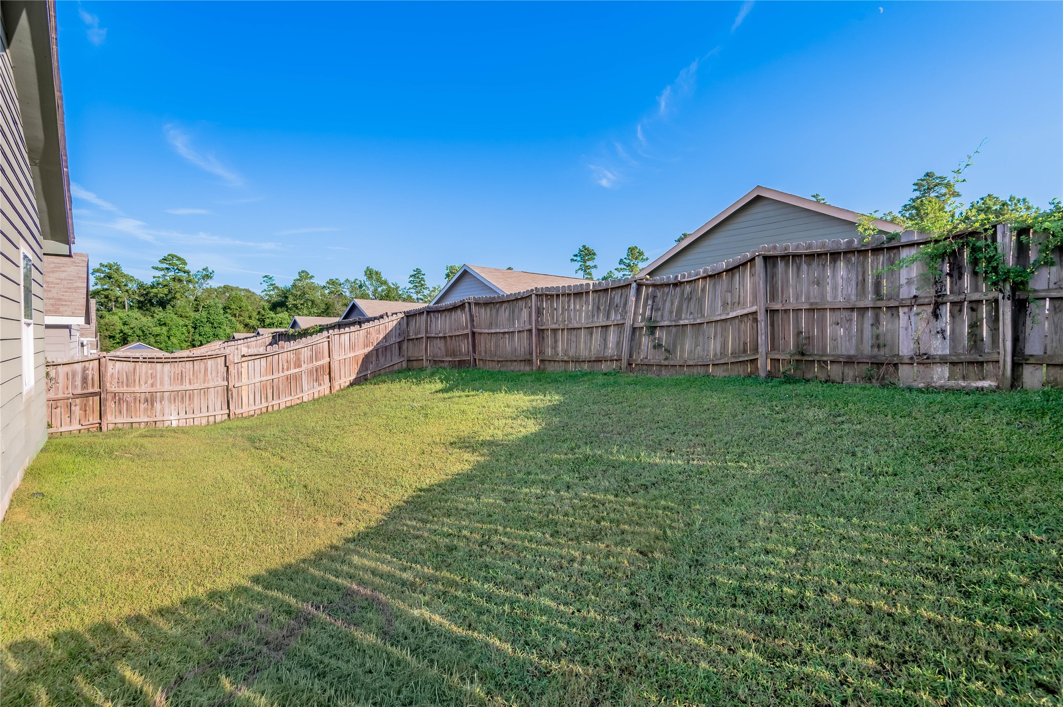 121 Varsity Circle Huntsville, TX 77340 - Photo 31 of 32 a view of a backyard with a garden and deck