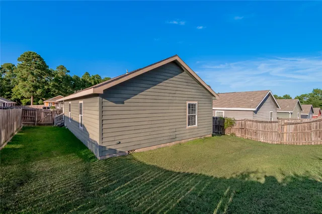 a view of a backyard with plants and large tree