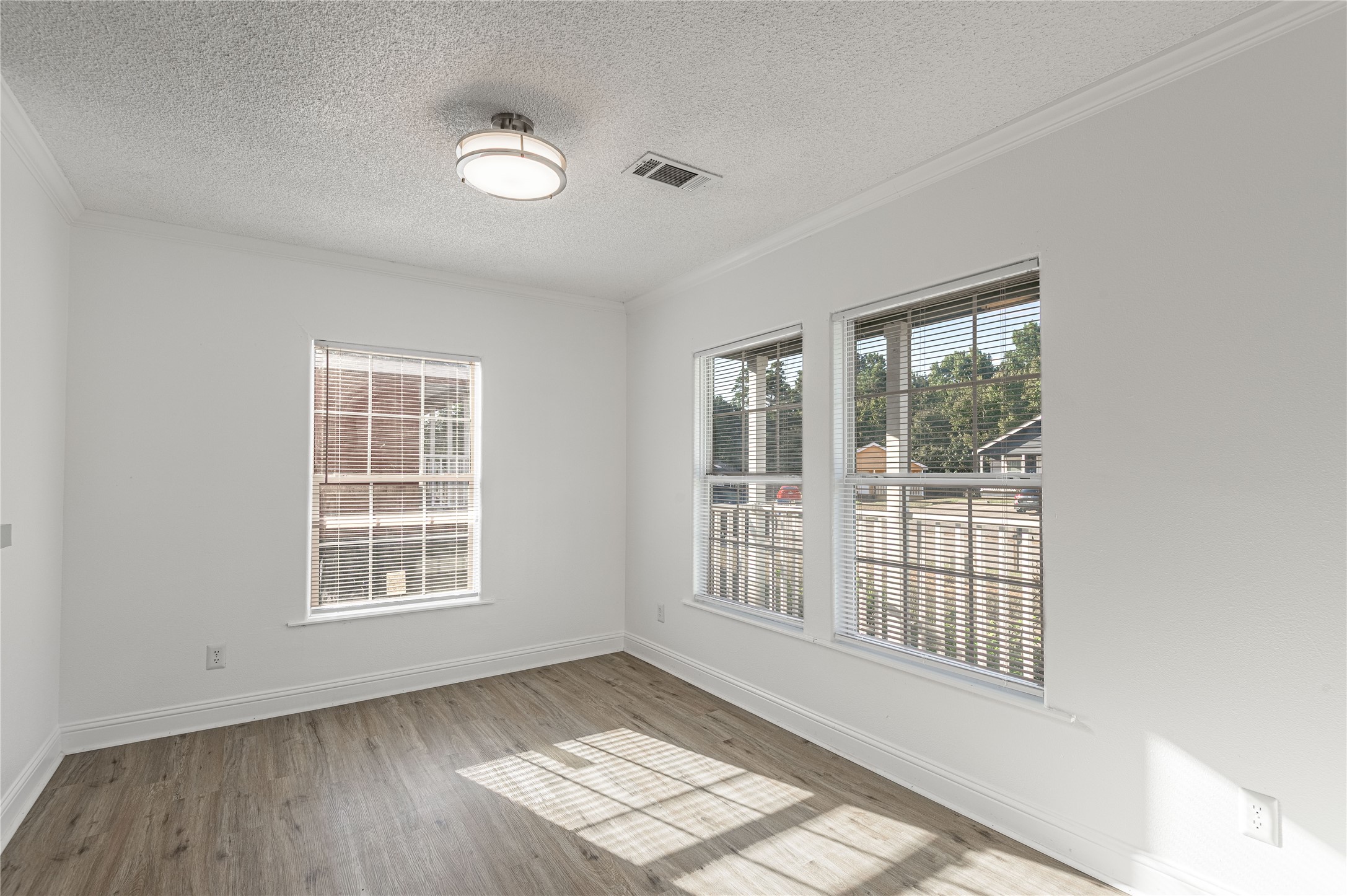 121 Varsity Circle Huntsville, TX 77340 - Photo 7 of 32 an empty room with wooden floor and windows