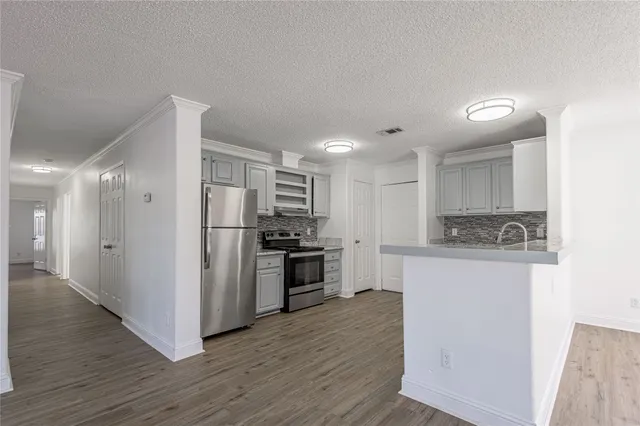 a kitchen with stainless steel appliances a refrigerator and a stove top oven