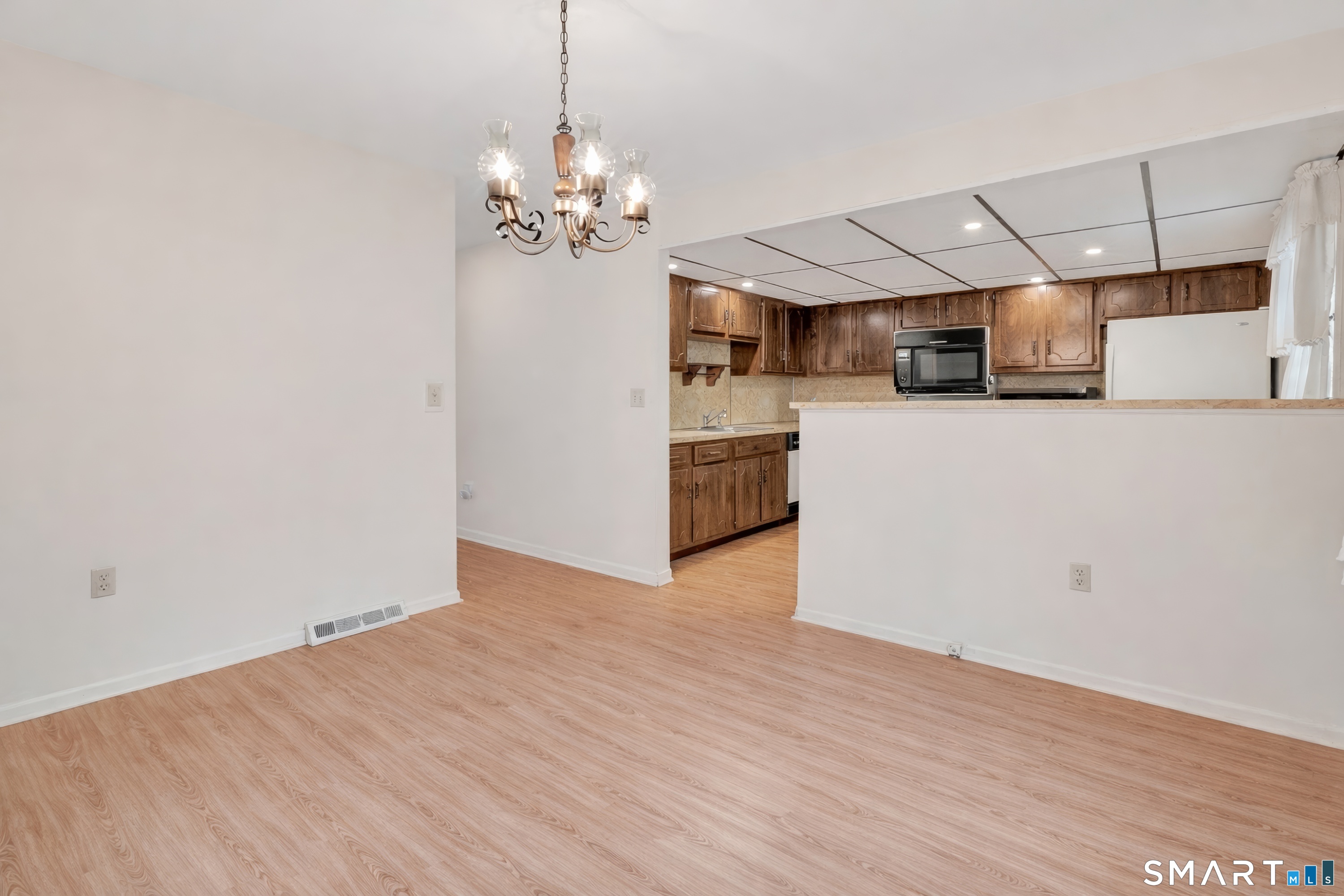 330 Merwin Avenue, Unit 1D Milford, CT 06460 - Photo 7 of 39 a view of a kitchen with a sink and dishwasher a refrigerator with wooden floor