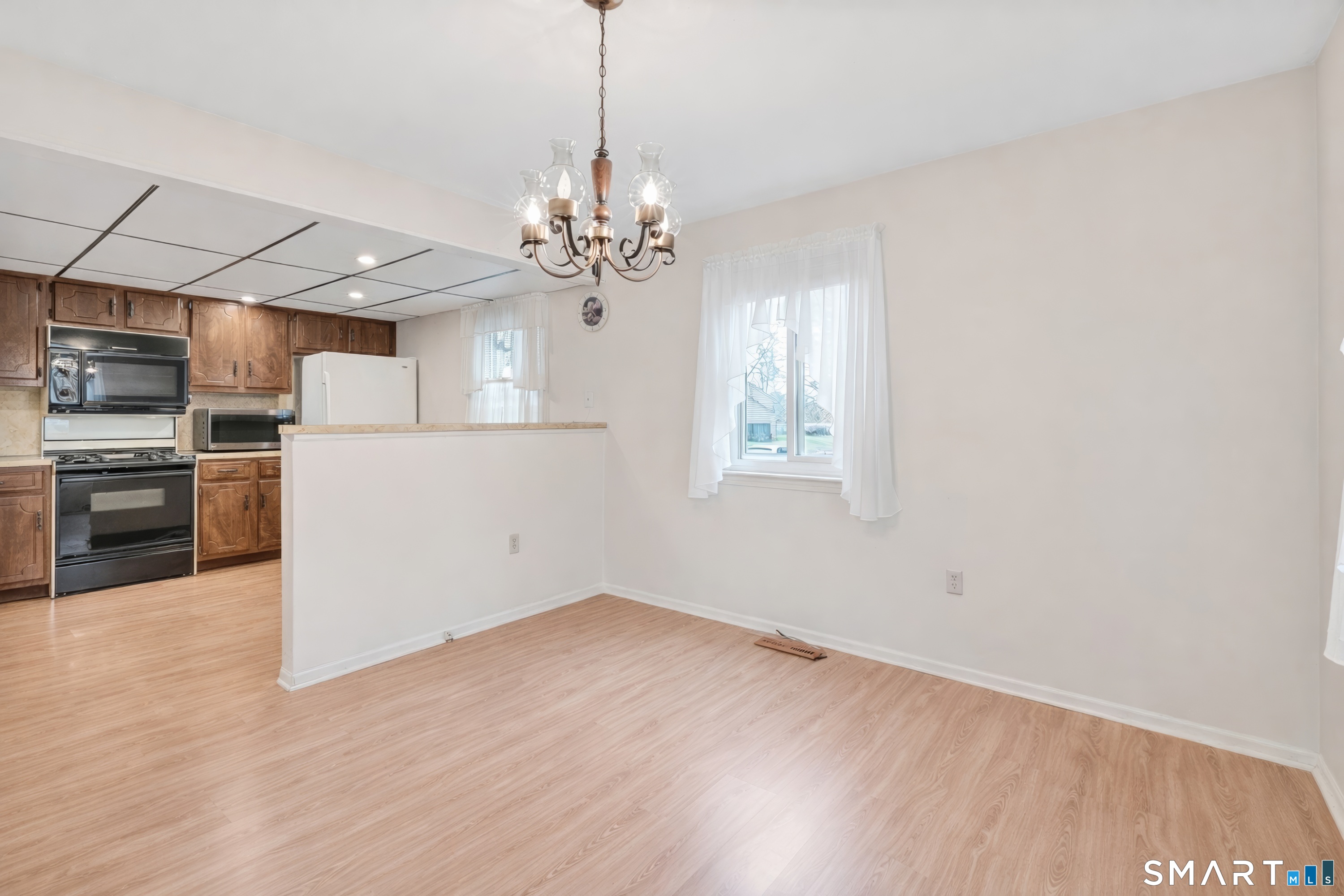 330 Merwin Avenue, Unit 1D Milford, CT 06460 - Photo 8 of 39 a view of a kitchen with a stove cabinets and a wooden floor