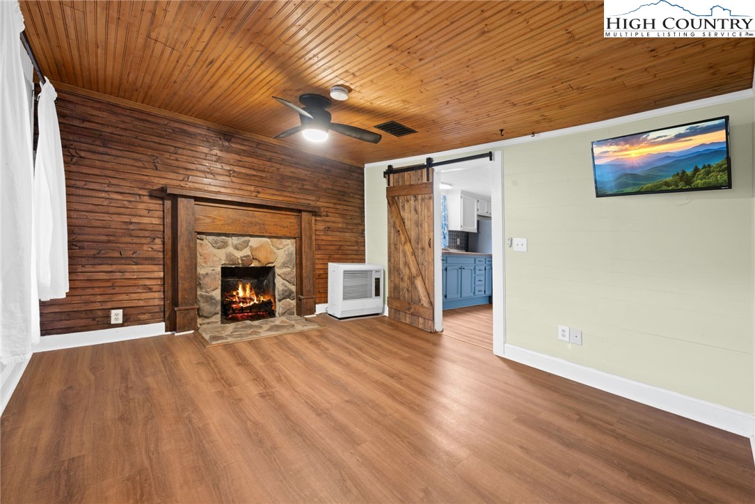 295 Jake's Mountain Road Boone, NC 28607 - Photo 11 of 47 a view of an empty room with wooden floor and a fireplace