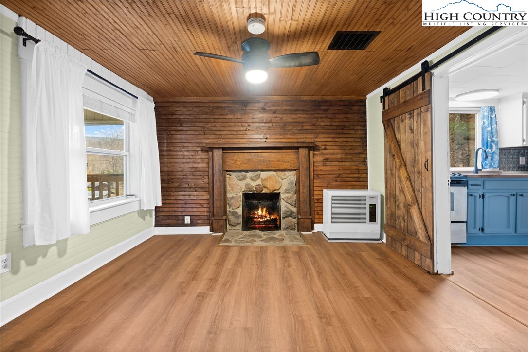 295 Jake's Mountain Road Boone, NC 28607 - Photo 12 of 47 a view of an empty room with wooden floor fireplace and a window