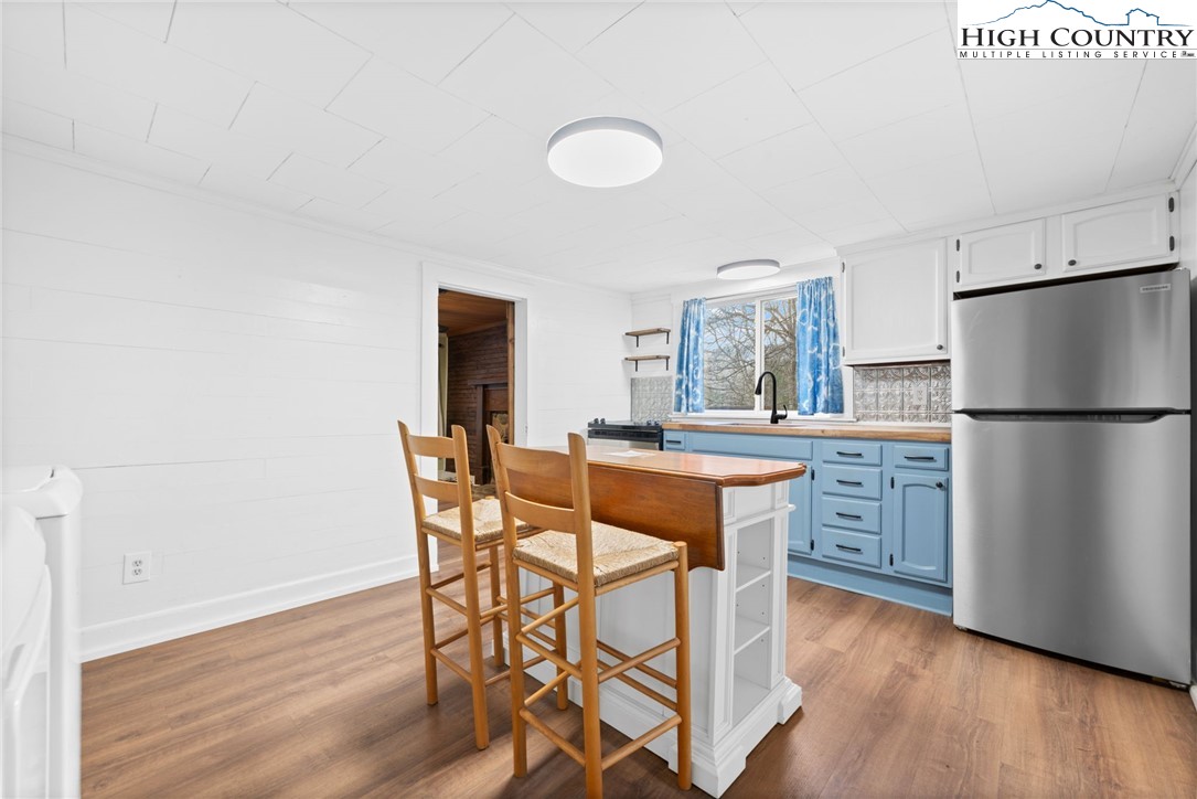 295 Jake's Mountain Road Boone, NC 28607 - Photo 7 of 47 a kitchen with stainless steel appliances granite countertop a dining table chairs and a refrigerator