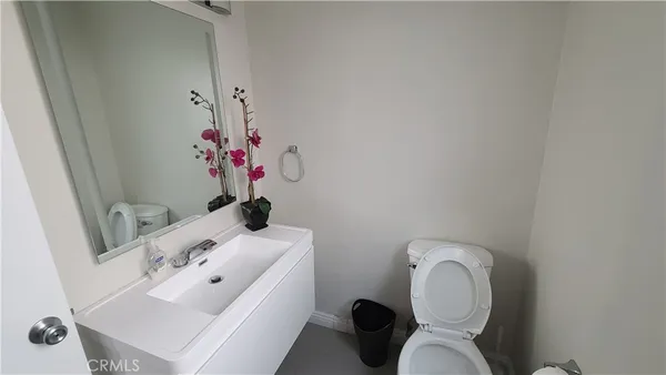 a bathroom with a toilet a sink and mirror