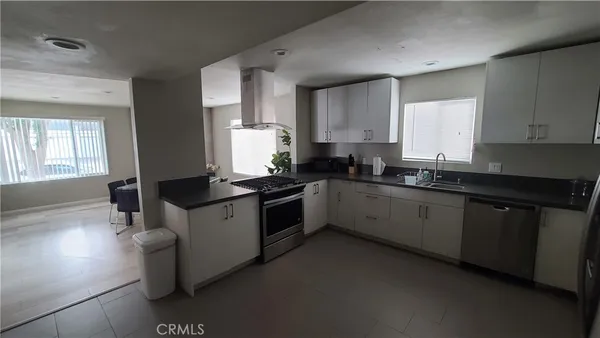 a kitchen with stainless steel appliances a sink stove and cabinets