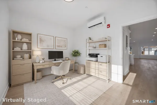 a living room with furniture a flat screen tv and kitchen view