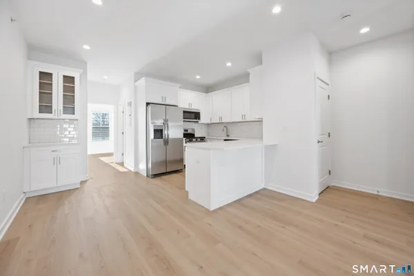 a view of a kitchen with wooden floor and electronic appliances