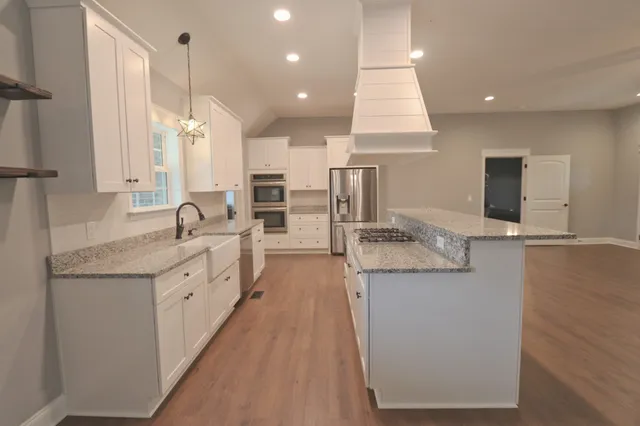 a large kitchen with stainless steel appliances kitchen island granite countertop a large counter top and sink