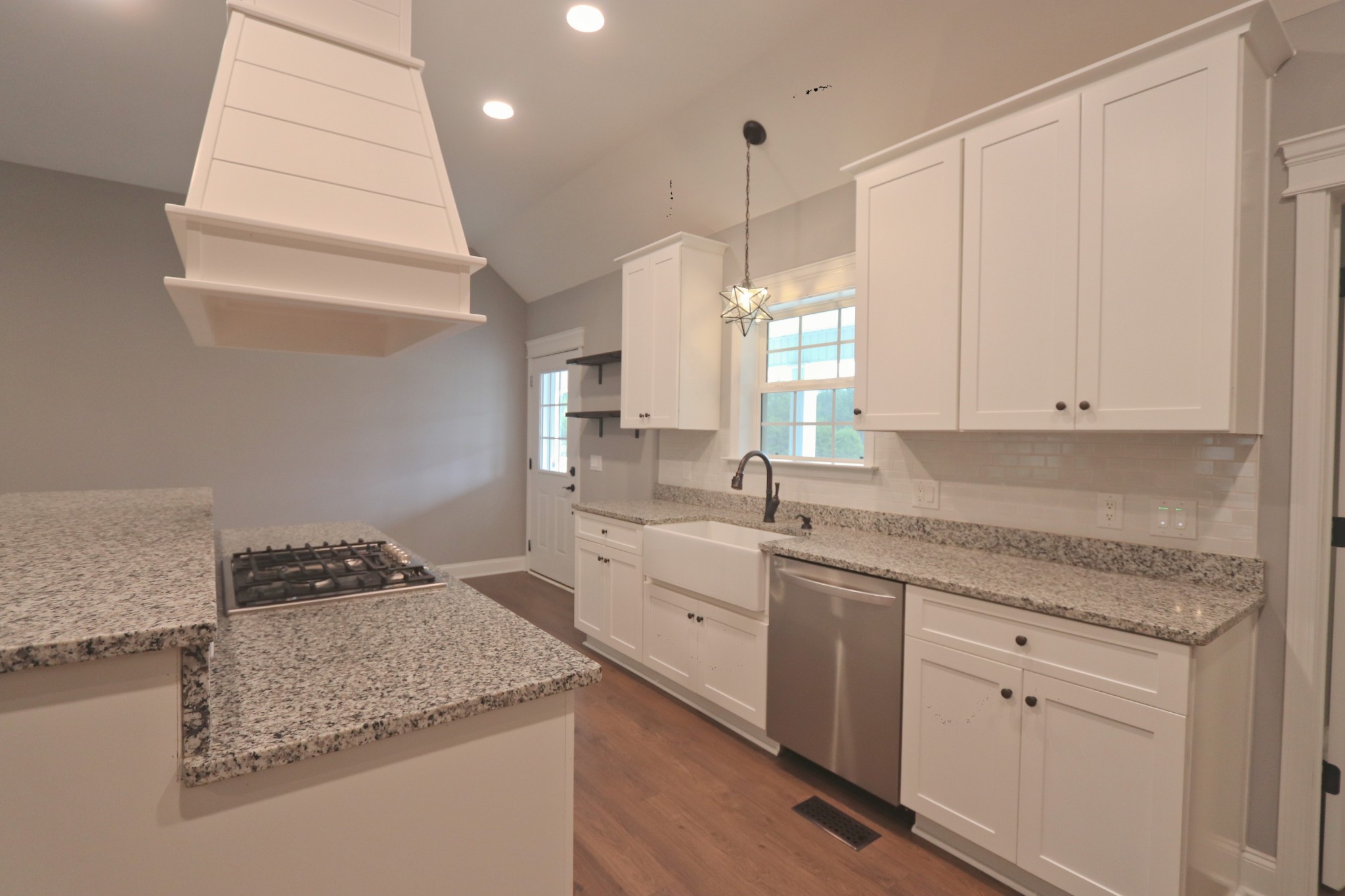 395 Harrison Road Shelbyville, TN 37160 - Photo 13 of 30 a kitchen with a sink dishwasher and white cabinets with wooden floor
