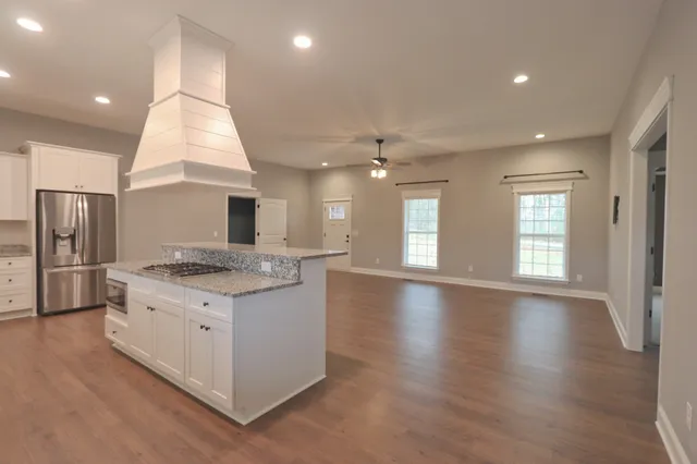 a kitchen with stainless steel appliances granite countertop a stove and a large refrigerator